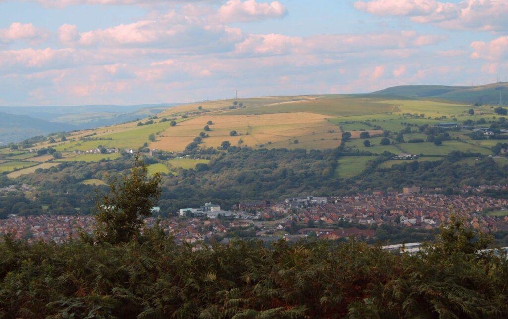 A view from Caerphilly Mountain showing a dramatic skyline and rows of terraced houses basking in the sun